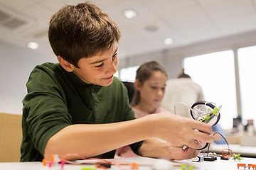 Image showing happy children building robot at robotics school