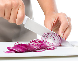 Image showing Cook is chopping onion