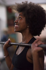 Image showing black woman lifting empty bar