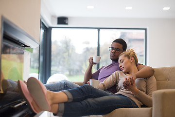 Image showing Young multiethnic couple  in front of fireplace