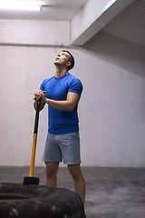 Image showing man workout with hammer and tractor tire