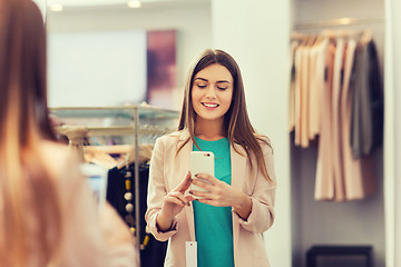 Image showing woman taking mirror selfie by smartphone at store