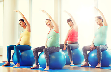 Image showing happy pregnant women exercising on fitball in gym