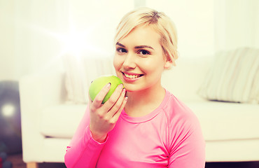 Image showing happy woman eating apple at home