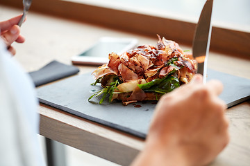 Image showing woman eating prosciutto ham salad at restaurant