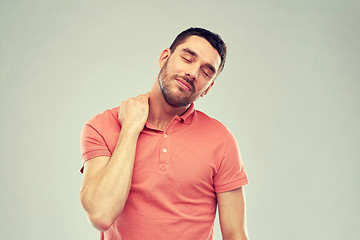 Image showing unhappy man suffering from neck pain