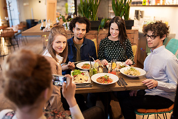 Image showing friends with smartphone fotographing at restaurant