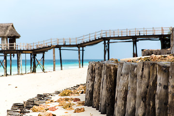 Image showing stilt bridge to bungalow hut on tropical beach