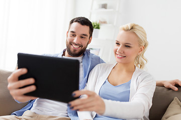 Image showing smiling happy couple with tablet pc at home