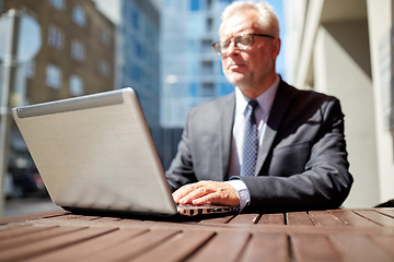 Image showing senior businessman with laptop at outdoor cafe