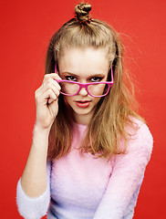 Image showing young pretty emitonal posing teenage girl on bright red background, happy smiling lifestyle people concept 