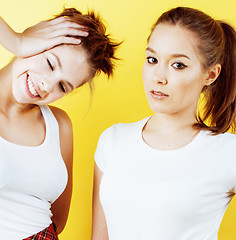 Image showing lifestyle people concept: two pretty young school teenage girls having fun happy smiling on yellow background 