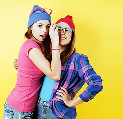 Image showing lifestyle people concept: two pretty young school teenage girls having fun happy smiling on yellow background 