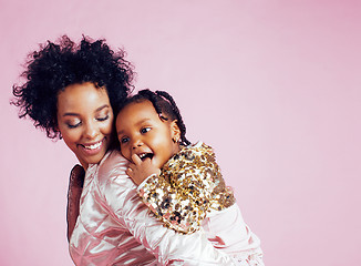 Image showing young pretty african-american mother with little cute daughter hugging, happy smiling on pink background, lifestyle modern people concept