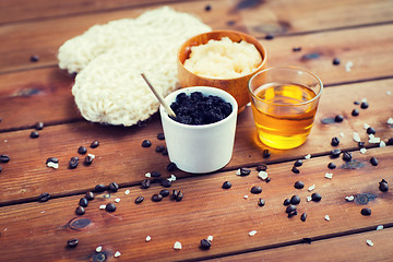 Image showing close up of coffee scrub in cup and honey on wood