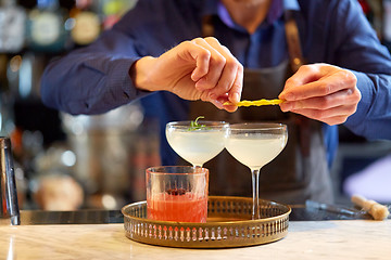 Image showing bartender with glass of cocktail and lemon at bar