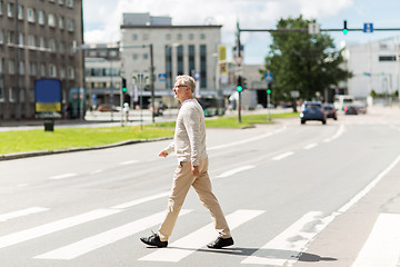 Image showing senior man walking along city crosswalk