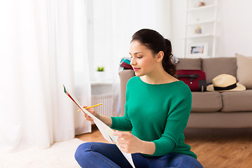 Image showing happy young woman with travel map at home