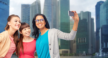Image showing international happy women taking selfie in city