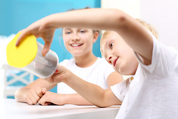 Image showing Magnetism, attraction. The child sees the phenomenon of magnetic field on the lessons of physics.