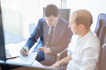 Image showing Two businessmen discussing a bisiness problem at meeting in trading office.