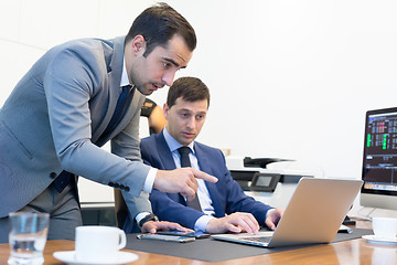 Image showing Business team remotely solving a problem at business meeting using laptop computer and touchpad.