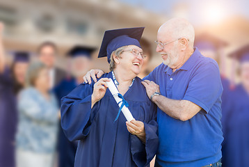 Image showing Senior Adult Woman In Cap and Gown Being Congratulated By Husban