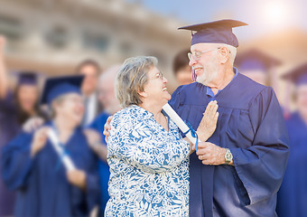 Image showing Senior Adult Male In Cap and Gown Being Congratulated By Wife At
