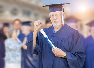 Image showing Proud Senior Adult Man In Cap and Gown At Outdoor Graduation Cer