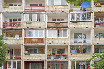 Image showing Old building with balconies full of flowers, tables, chairs