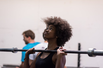 Image showing black woman lifting empty bar