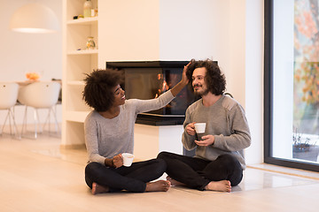 Image showing multiethnic couple  in front of fireplace