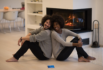 Image showing multiethnic couple with tablet computer on the floor