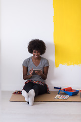 Image showing back female painter sitting on floor