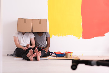 Image showing young multiethnic couple playing with cardboard boxes