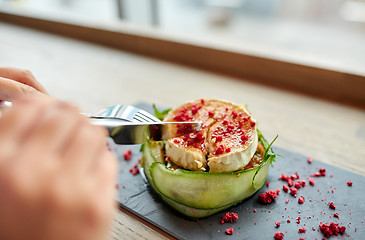 Image showing woman eating goat cheese salad at restaurant