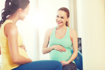 Image showing two happy pregnant women sitting on balls in gym