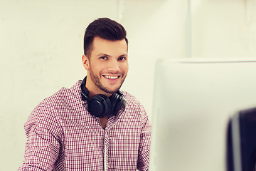 Image showing creative man with headphones and computer