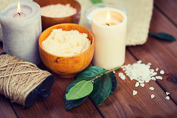 Image showing close up of natural body scrub and candles on wood