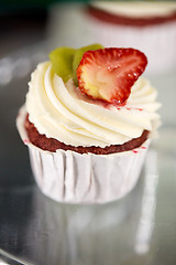 Image showing close up of cupcake with cream and strawberry