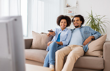 Image showing smiling couple with remote watching tv at home