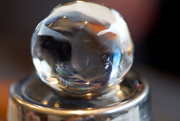 Image showing hand-cut ice ball on top of cocktail shaker at bar