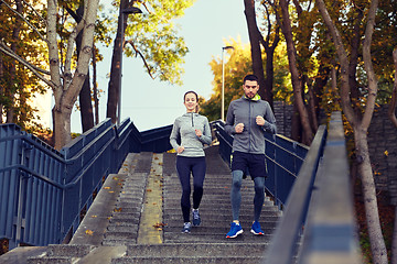 Image showing happy couple running downstairs in city