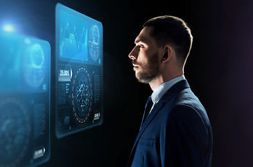 Image showing businessman looking at virtual screens over black