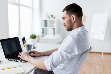 Image showing businessman typing on laptop at office