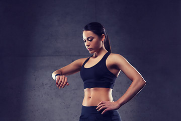 Image showing young woman with heart-rate watch in gym