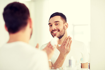 Image showing happy man applying shaving foam at bathroom mirror