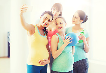 Image showing pregnant women taking selfie by smartphone in gym