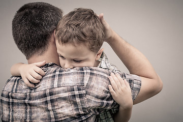 Image showing sad son hugging his dad