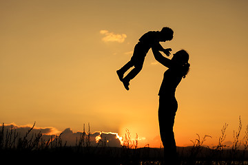 Image showing Mother and son playing on the coast of lake